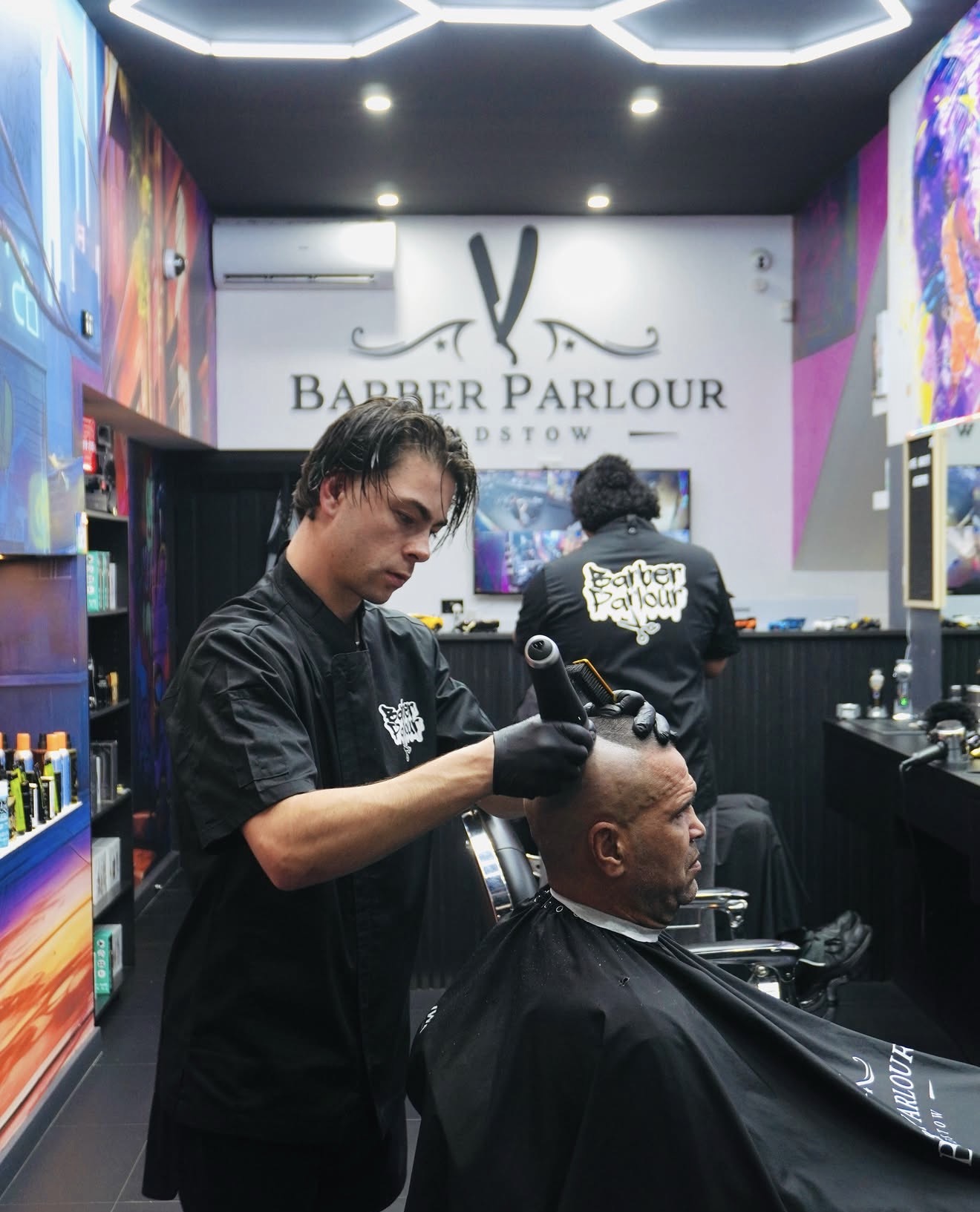 Inside Barber Parlour Padstow — barber working under hexagon lights